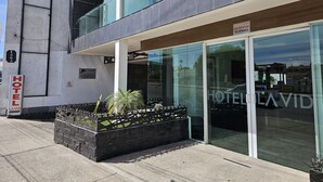 A modern hotel with a glass facade, a balcony, and a sign indicating it is a hotel named "HOTEL LAVID". - La Vid Aguascalientes (Aguascalientes)