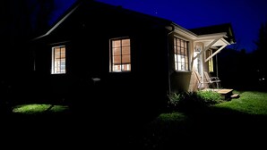 Una casa de noche con dos ventanas y un porche.