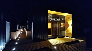 A modern Bacaris Hotel entrance with a wooden deck leading to the doors, illuminated by ambient lighting. - HOTEL BACARIS (Río Ibáñez)