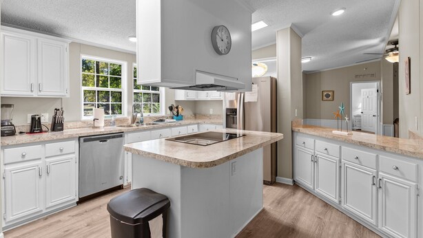 A modern kitchen with white cabinets, a large island, and a built-in oven. - Sand Dollars - 5mins to beach, huge lot, pet friendly and boat parking!  (Ocean Isle Beach)