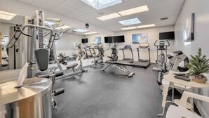 A gym with various exercise equipment, including treadmills, stationary bikes, and weight machines. - Camelback mountain condo with incredible views! Quick walk to the slopes!  (Tannersville)