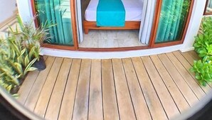 A bedroom with a bed, curtains, and a wooden floor. - Hotel Casa Shula Acapulco (Coyuca de Benitez)