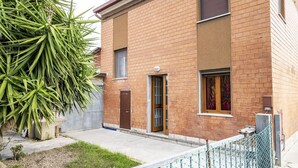 Un edificio de ladrillo de dos pisos con una puerta principal, una ventana pequeña y un buzón a la vista.