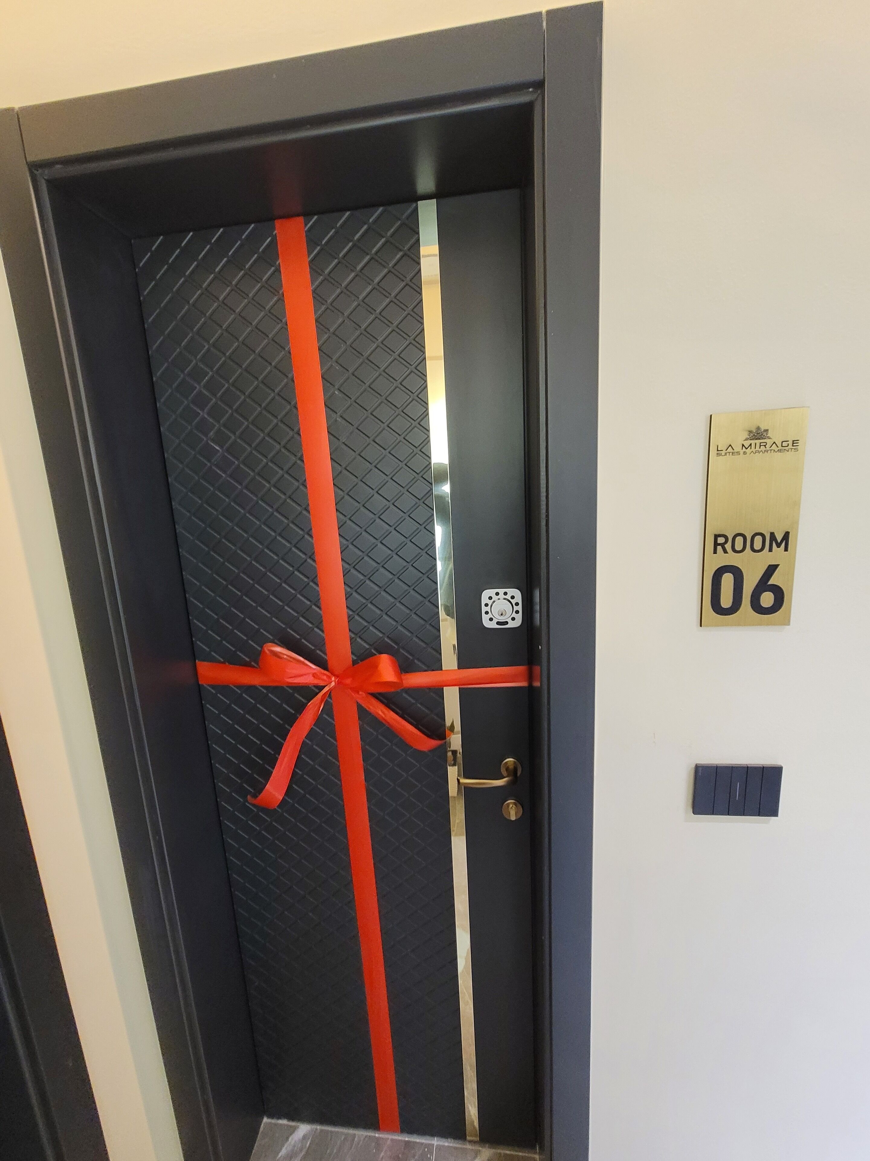 A door with a red ribbon, a room number sign, and a keyhole.