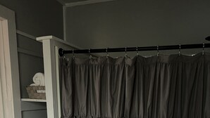 A bathroom with a shower curtain, a towel rack, and shelves with towels. - The House on East Main: 5 mins to downtown and 5 mins to SFA University (Nacogdoches)