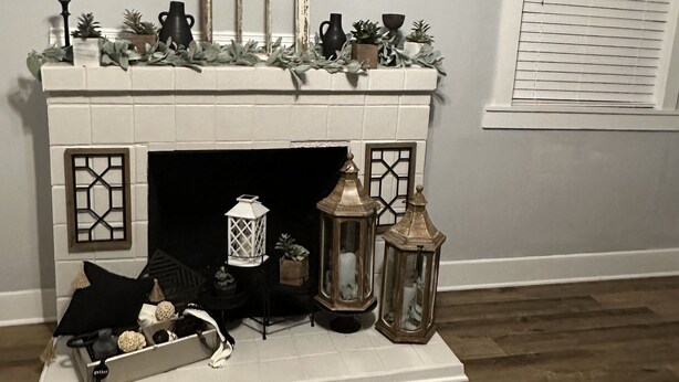 A fireplace with decorative items, a mirror above it, and a window with blinds. - The House on East Main: 5 mins to downtown and 5 mins to SFA University (Nacogdoches)