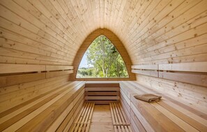 Eine Sauna mit Holzbänken und einem großen Bogenfenster.