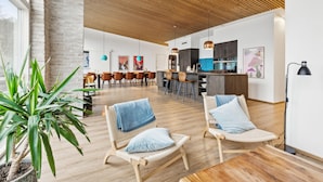 Un intérieur moderne comprenant un coin repas, une cuisine et un espace détente agrémenté d’une plante.