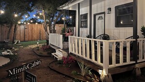A cabin with a porch, a sign indicating a restroom, and a sign for Mimi's Cabin.