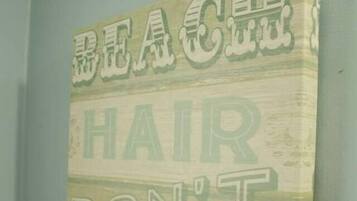 Una pared con un letrero que dice 'BEACH HAIR DON'T CARE' en letras grandes.