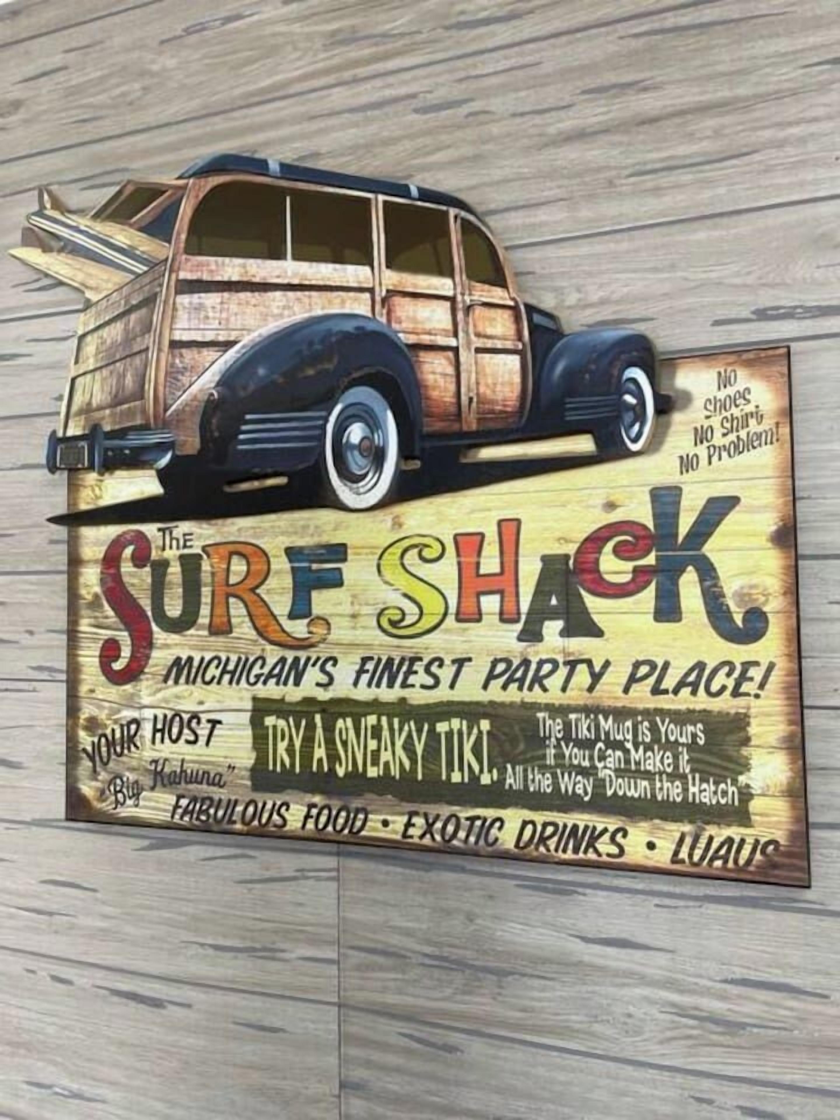En träskylt med en illustration av en klassisk bil och text som marknadsför ”The Surf Shack” som Michigans bästa festplats, där man kan få mat, dryck och en tiki-mugg.