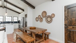 Eine moderne Küche mit einem Holzespeisetisch, Bänken und einer großen Holztür.