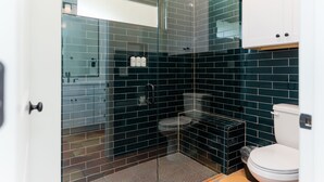 A modern bathroom with a glass-enclosed shower, a white toilet, and a tiled backsplash. - 1 Bedroom Villa (Double Queen) (Nemo)