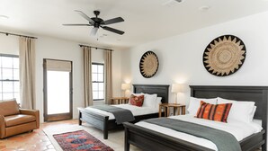 A bedroom with two beds, a ceiling fan, a large rug, and a view of the outside. - 3 Bedroom Casita (6 Queen Beds) (Nemo)