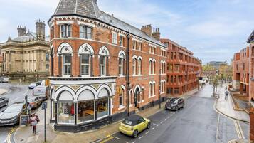 A corner building with a shop on the ground floor and residential units above.