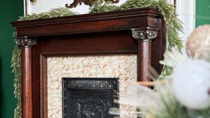 Een open haard met een decoratieve mantel en een spiegel erboven.
