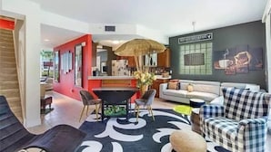 A modern living room with a dining area, a kitchen in the background, and a sign for 'Cold and Breakfast'. - Little Harbor Resort at Bahia Beach (Ruskin)