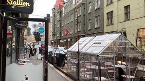 A street view with a cafe named Cafe Scallon, a glass greenhouse structure, and historic buildings with red roofs. - Central stay in Helsinki (Helsinki)