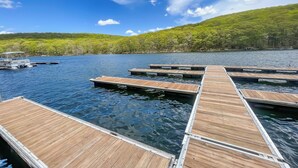 Un moll de fusta que s'endinsa en un llac, amb una barca aparcada al final.