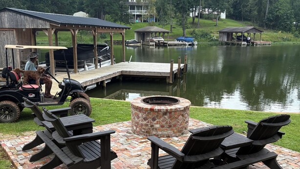 A lakeside deck with outdoor seating and a fire pit. - Lakefront Property 
Fish, Cook and EAT!
Swim, Float, Relax (Sparta)