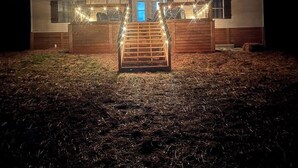 A two-story house with a wooden deck and a front gate. - Lakefront Property 
Fish, Cook and EAT!
Swim, Float, Relax (Sparta)