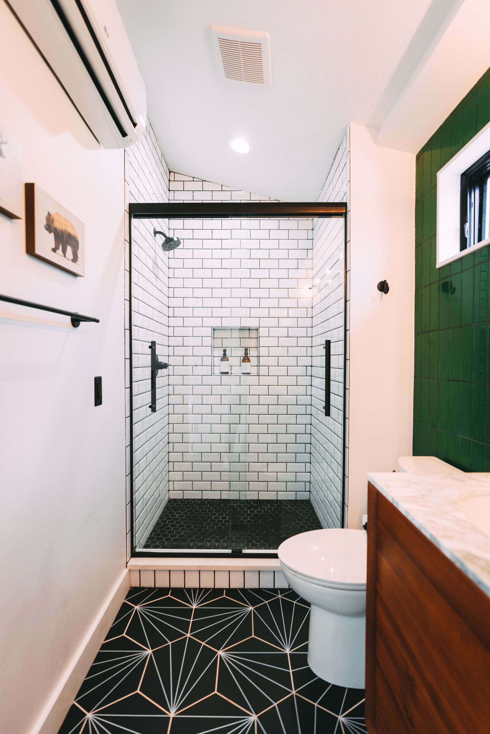 A bathroom with a shower area, a toilet, and a sink.