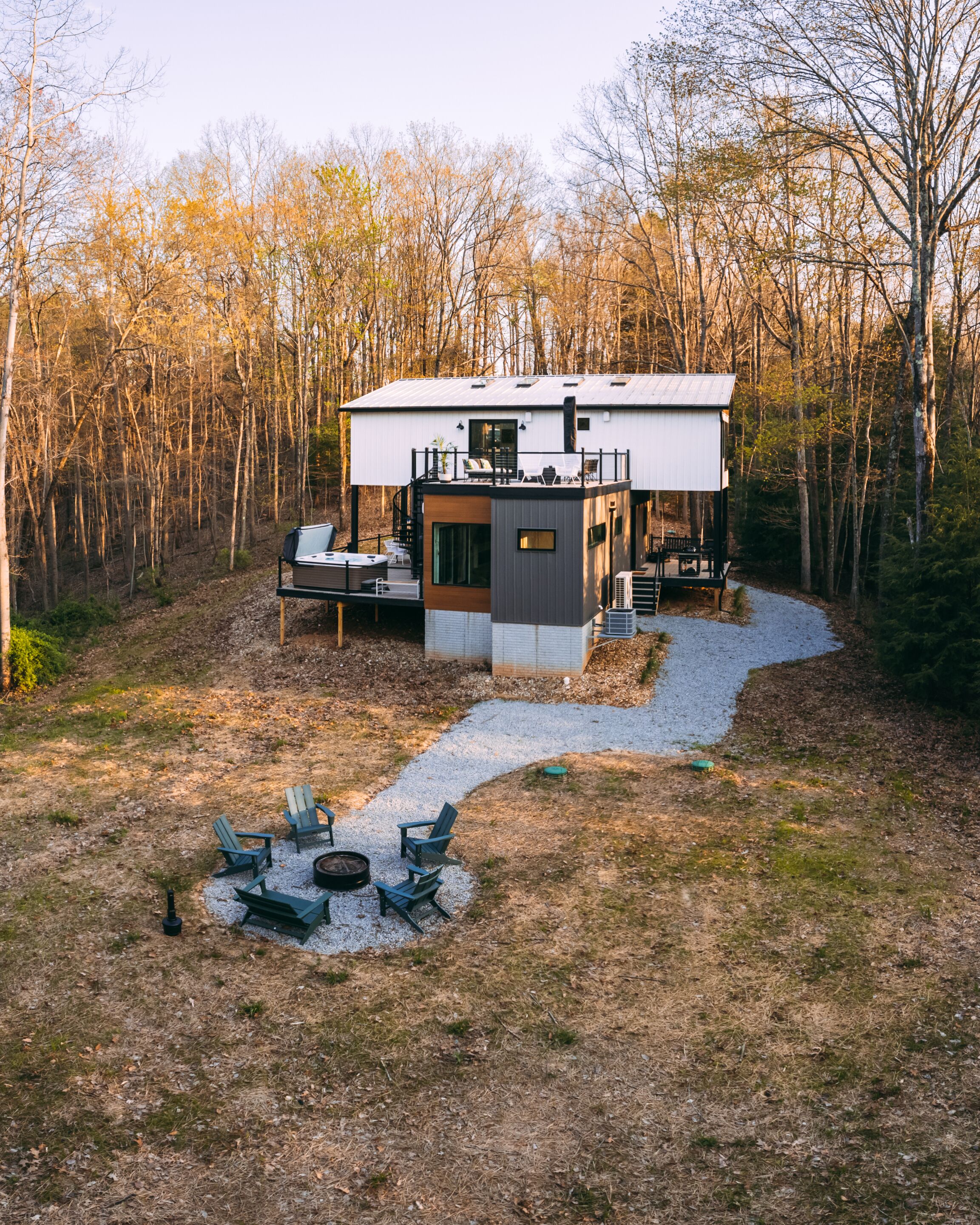 Een moderne chalet met terras, buitenmeubels en vuurkorf.