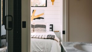 A bedroom with a bed, a ceiling fan, and a window.