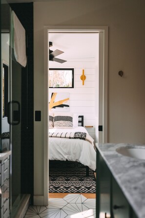 Un dormitorio con cama, ventilador de techo y ventana.