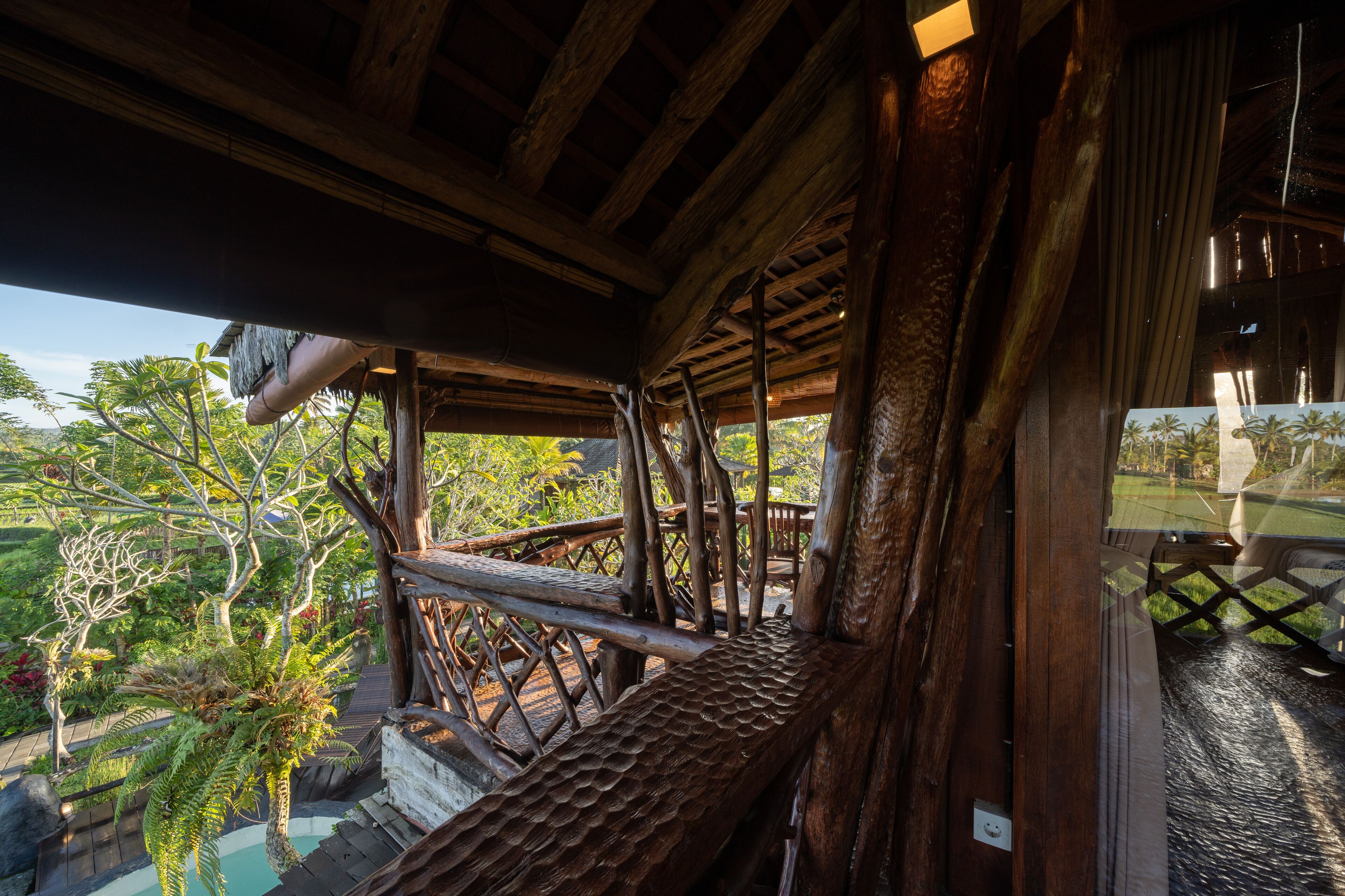 Una estructura de madera con vistas a exuberante vegetación y una piscina.