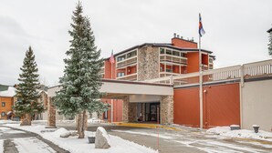 A hotel with a stone facade, multiple balconies, and an American flag.