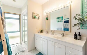 A bathroom with a large mirror, white cabinets, a sink, and a window. - Great-Located North Shore Room in Tropical Garden – Close to the Beach 🌴🌊 (Auckland)
