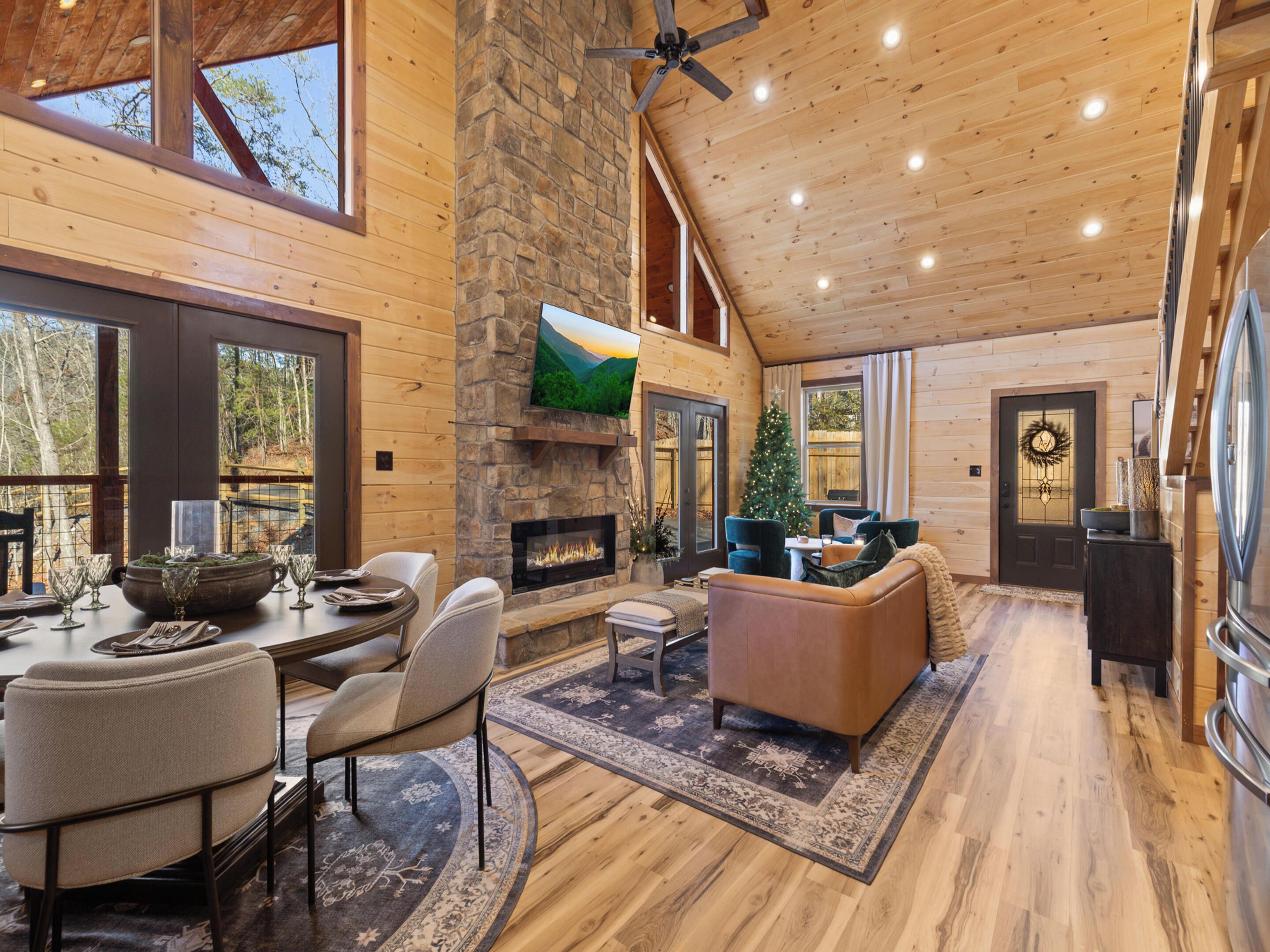 Un salón amplio con chimenea, asientos cómodos y ventanas grandes que ofrecen vistas al exterior.