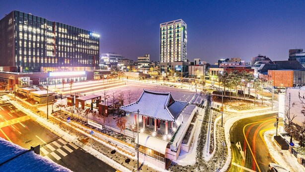 A modern urban area with a traditional building featuring a curved roof and a central pavilion. - Chuncheon Bella Residence Hotel (Chuncheon)