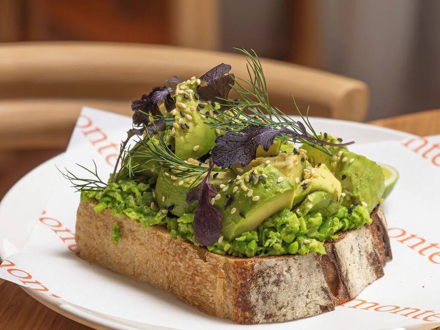 A sandwich on a white plate with a menu underneath.