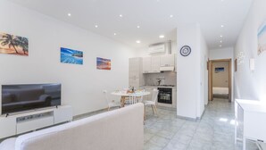 Un appartement moderne comprenant un salon, une cuisine et un coin repas.