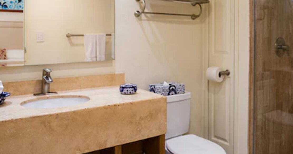 A bathroom with a sink, toilet, and shower area.