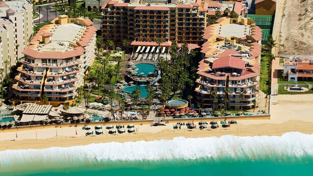 A resort with multiple buildings, a central pool area, and a beach with sun loungers. - Villa del Palmar (Cabo San Lucas)