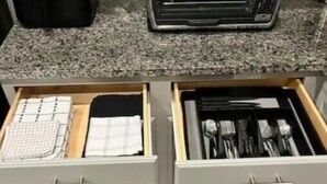 Cozinha com duas gavetas contendo utensílios de cozinha e um caderno.
