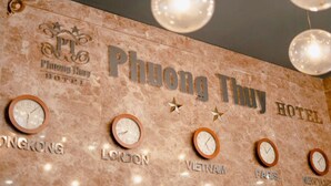 A wall with clocks indicating different time zones and the name "Phong Thuy Hotel". - Phuong Thuy Hotel Thu Duc near QL13 (Ho Chi Minh City)