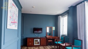 A hotel room with a wooden floor, a TV, a desk, a chair, and a window with curtains. - Phuong Thuy Hotel Thu Duc near QL13 (Ho Chi Minh City)