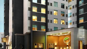 A modern hotel with a prominent logo on the facade, multiple floors, and a well-lit entrance. - Element by Marriott Charlotte Uptown (Charlotte)