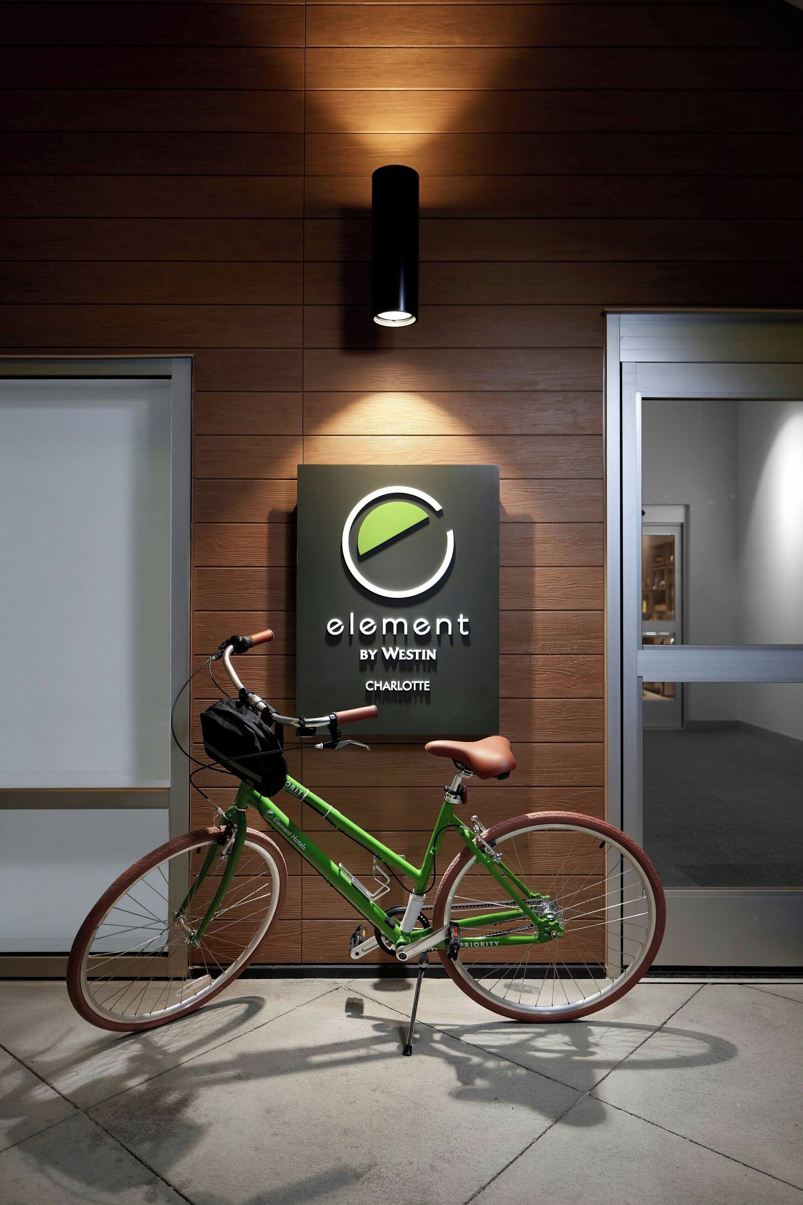 A modern interior with a wooden wall, a framed sign, and a green bicycle.
