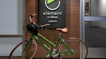 A modern interior with a wooden wall, a framed sign, and a green bicycle.