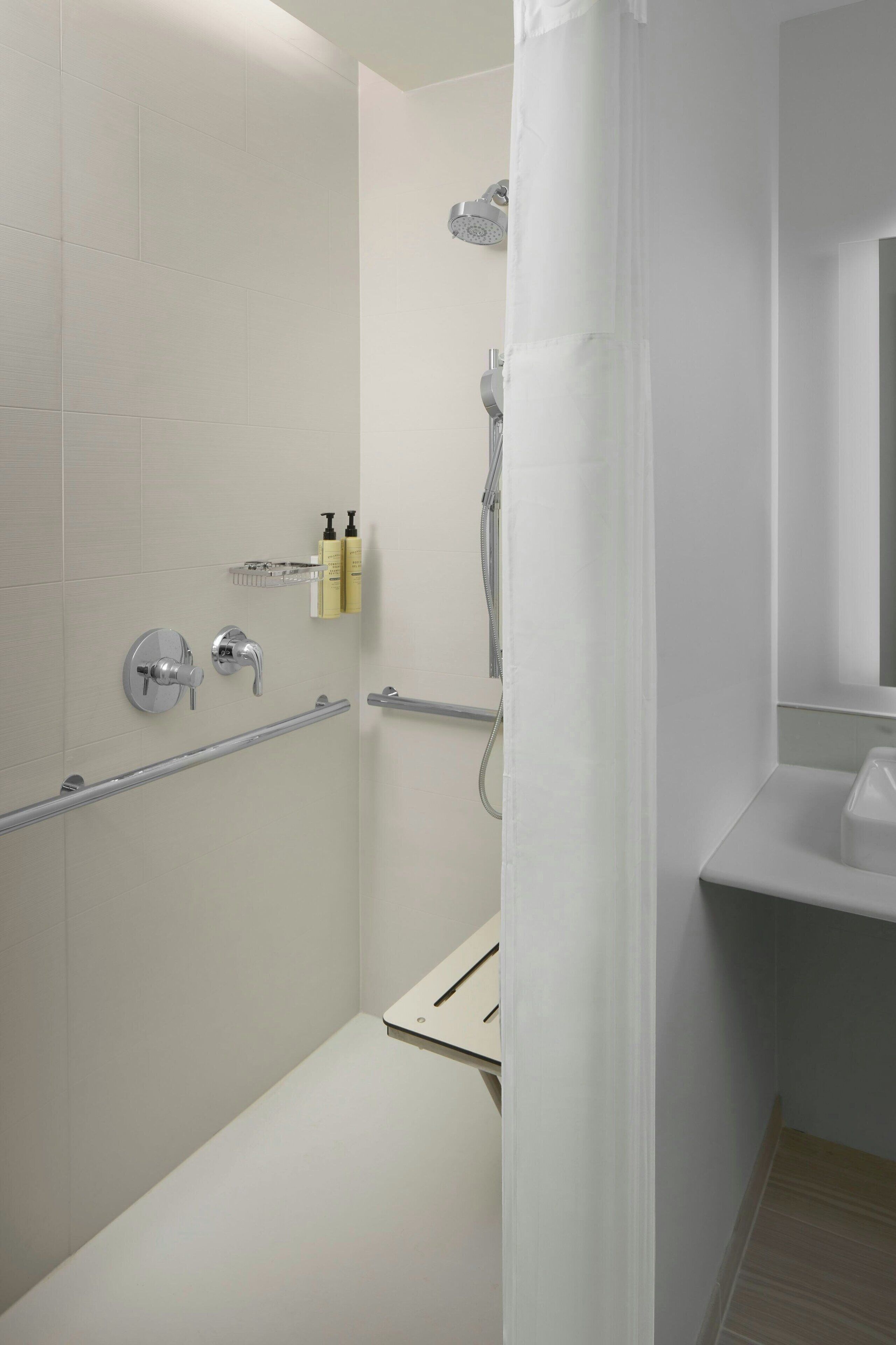 A modern bathroom with a shower, a toilet, and a sink.