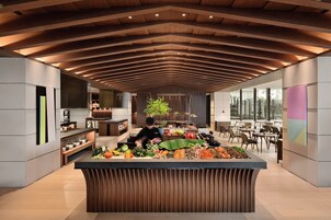 Una cocina moderna con una isla central, techo de madera y ventanas amplias.
