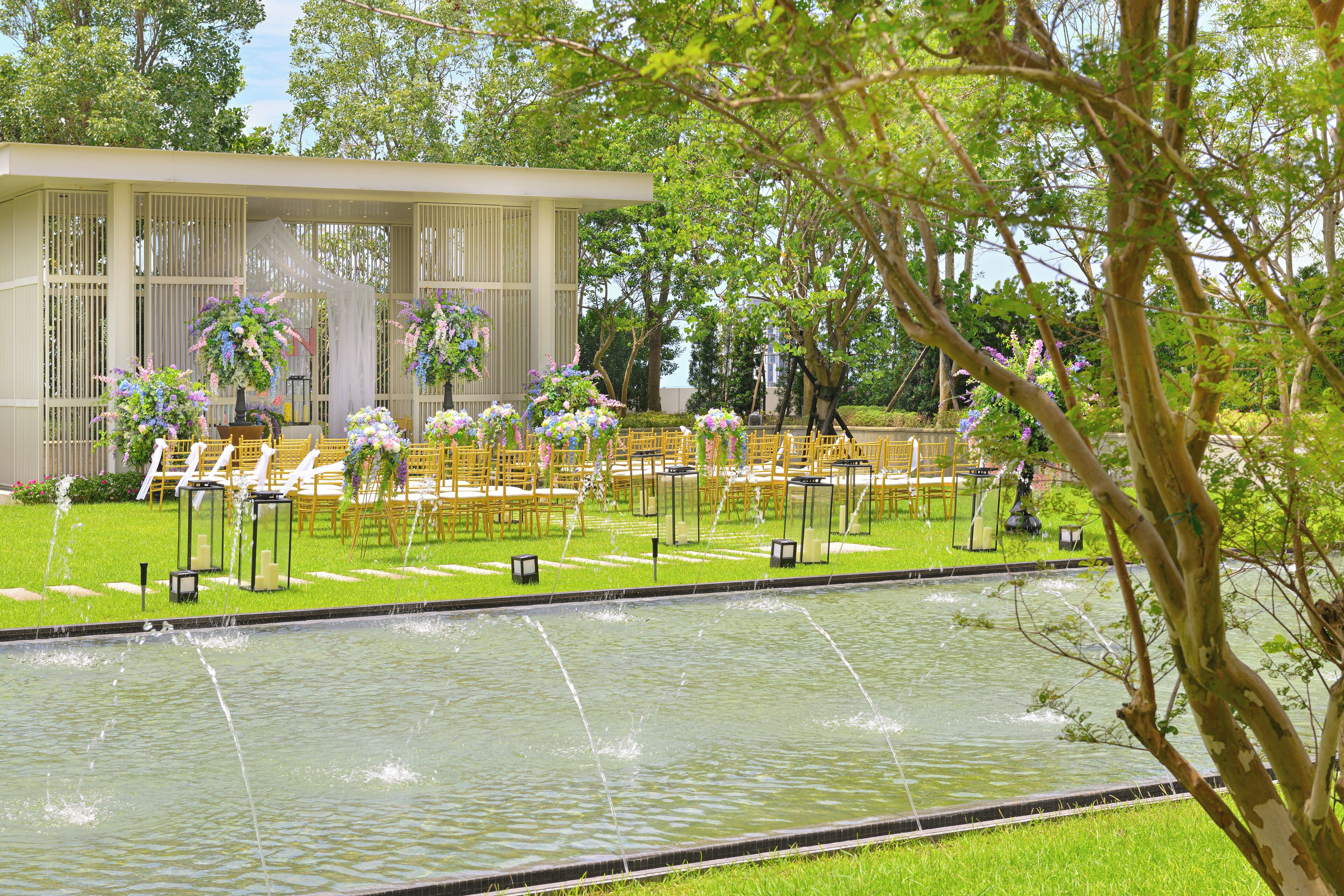 Un entorno tranquilo al aire libre con piscina, sillas y un edificio con zona cubierta.
