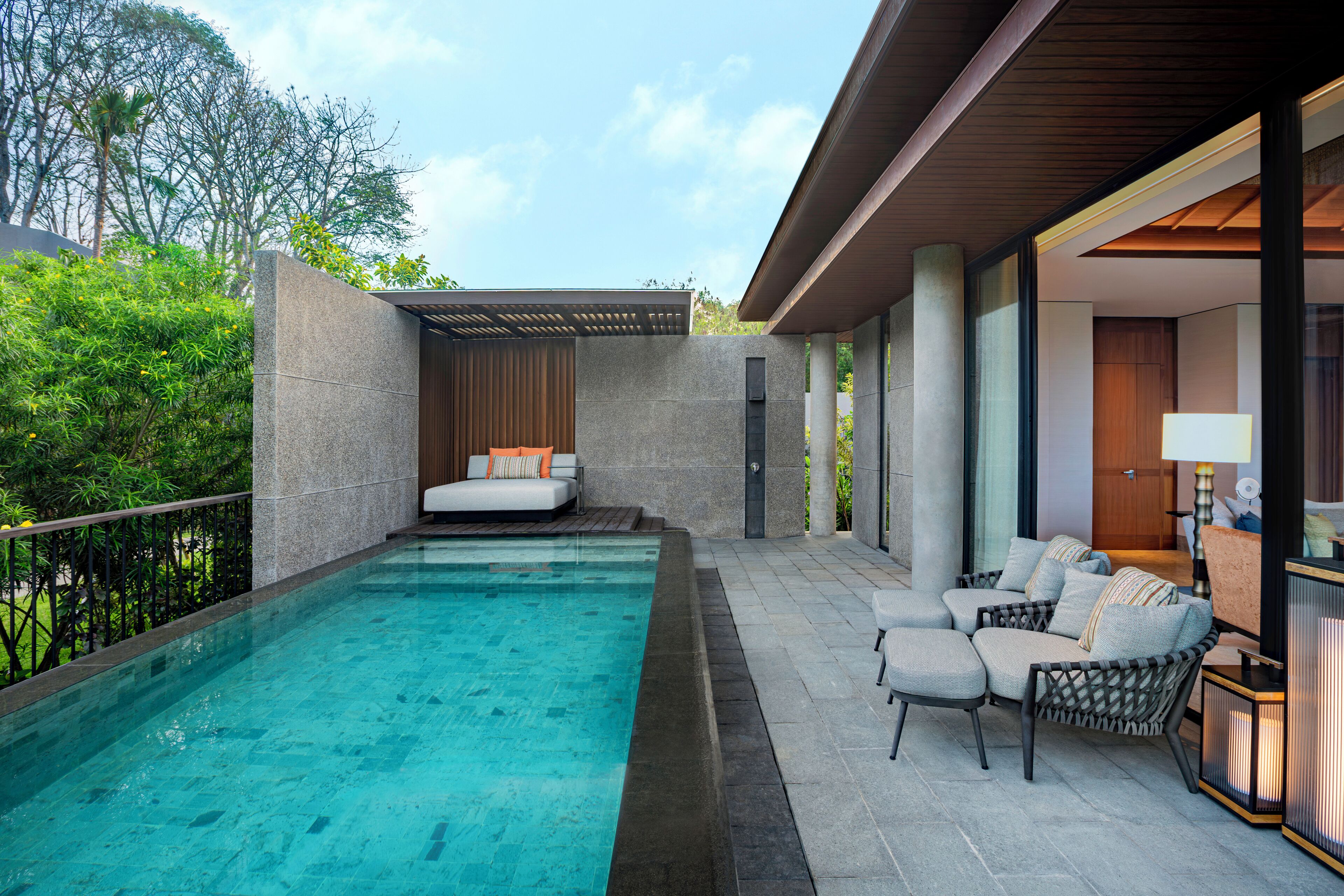 A modern outdoor pool area with a seating area and lounge chairs.