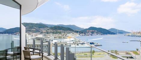 Un balcone con vista su una città costiera, inclusi un ponte e un tratto d'acqua.