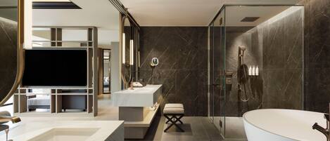 A modern bathroom with a large bathtub, a glass-enclosed shower, and a vanity with a mirror.